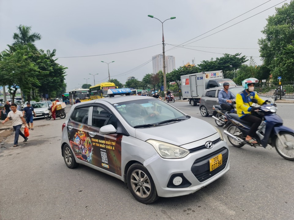 Một chiếc taxi của h&atilde;ng Vinasao d&aacute;n quảng c&aacute;o web c&aacute; độ ngang nhi&ecirc;n diễu phố.