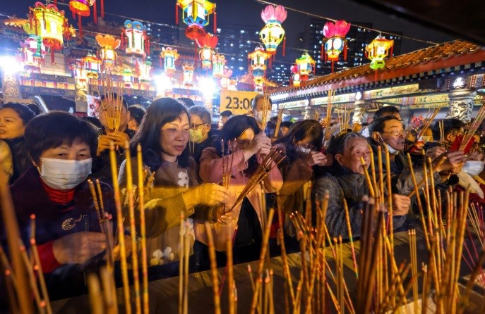 Những người thờ c&uacute;ng d&acirc;ng hương tại ch&ugrave;a Wong Tai Sin, Hong Kong v&agrave;o đ&ecirc;m giao thừa &acirc;m lịch. Ảnh: SCMP