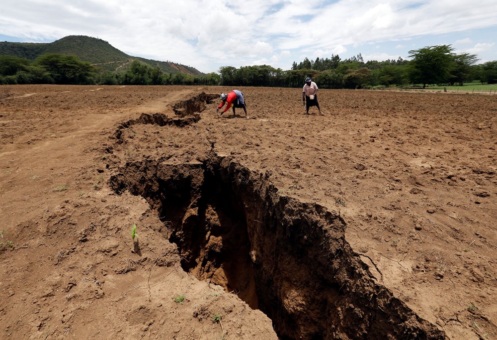 Những người phụ nữ làm việc trên trang trại của họ gần một vực thẳm được cho là do một trận mưa lớn gây ra dọc theo đường đứt gãy ngầm gần thị trấn Rift Valley của Mai Mahiu, Kenya ngày 28 tháng 3 năm 2018. Ảnh chụp ngày 28 tháng 3 năm 2018. REUTERS/Thomas Mukoya